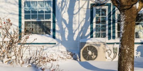 Air source heat pump on side of house
