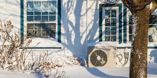 Air source heat pump on side of house
