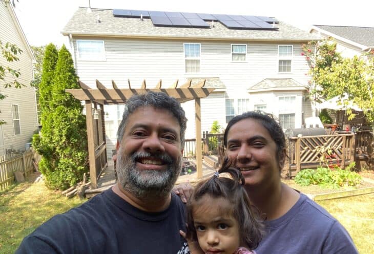 Clean Energy CU members posing in front of their house with new solar panels.