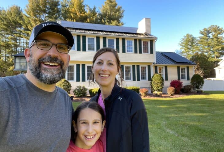 3 Clean Energy CU members posing in front of their house with new solar panels.