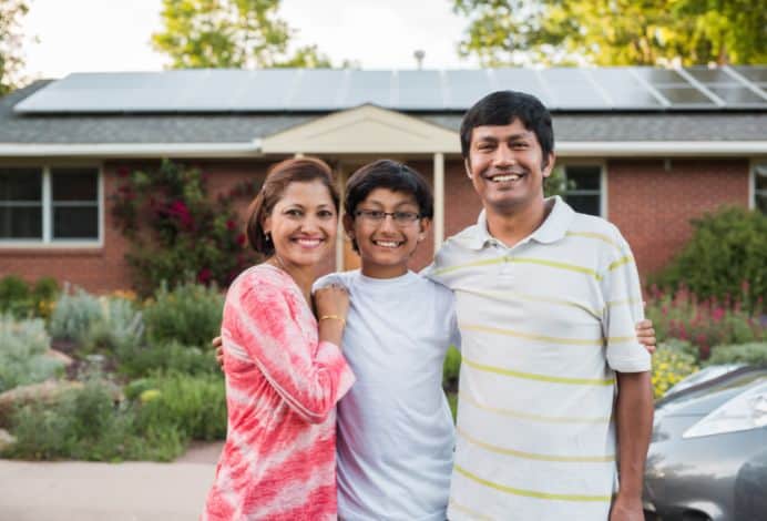 Family in front of their home with solar panels