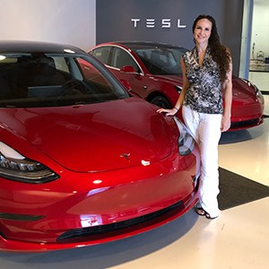 woman standing in front of Tesla electric vehicle