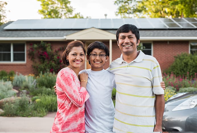 family in front of home with solar