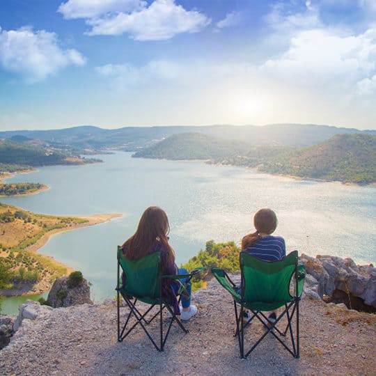 couple enjoying view of sunset over lake