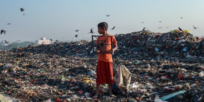 child standing in trash island