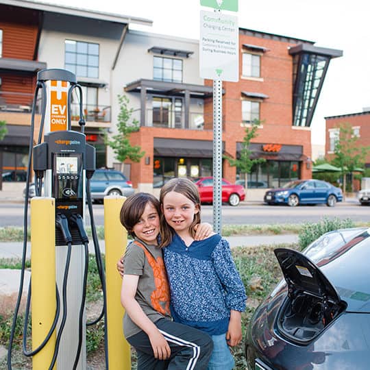 siblings recharging an electric vehicle